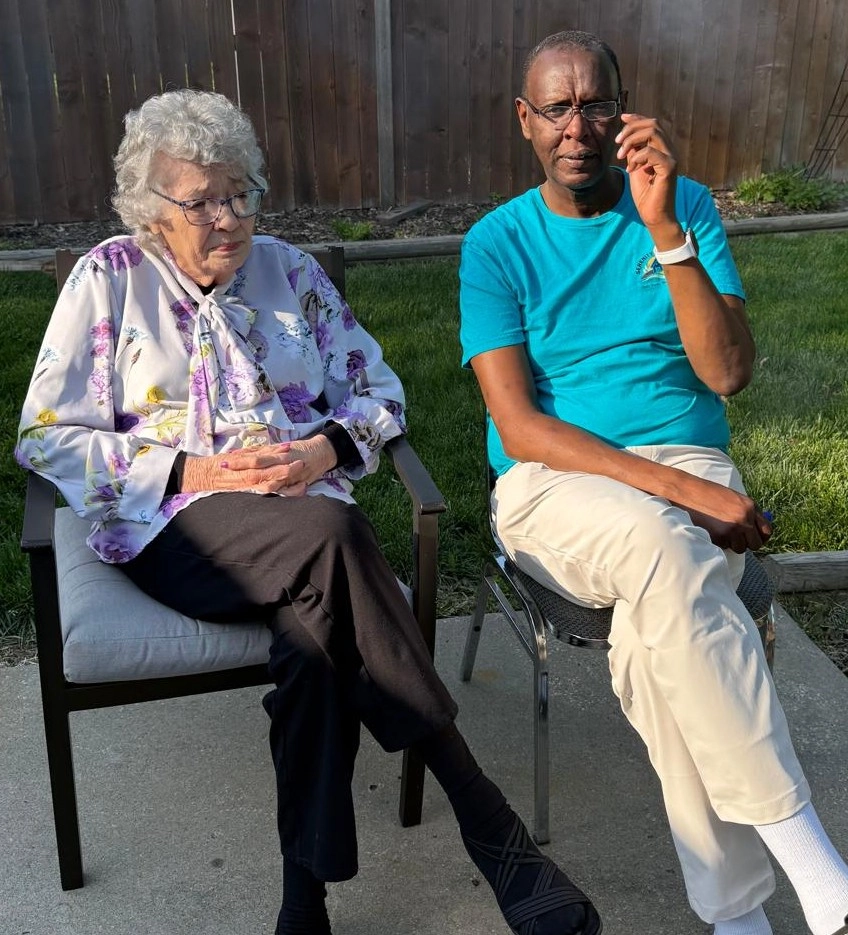 Caregiver Sitting With An Elderly Woman Providing Companionship And Support